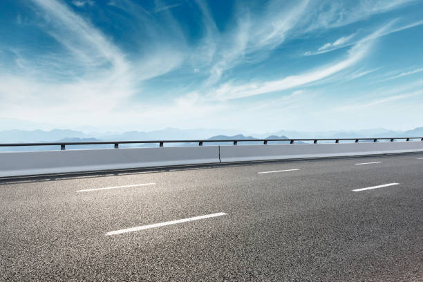 istock Asphalt road and mountains with white clouds 1065270984