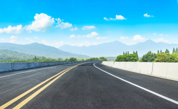 istock Asphalt road and mountains with white clouds 1065273856