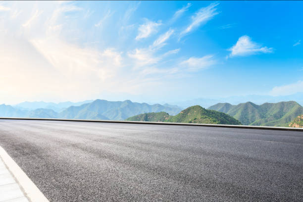 istock Asphalt road and mountains with white clouds 1065274386