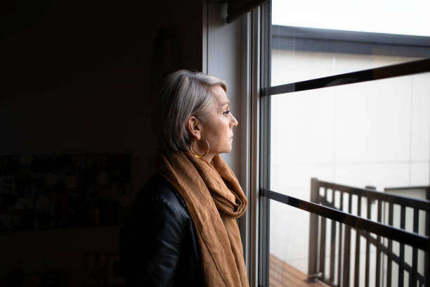 istock Serious Woman looking outside window with meditation 1065274458