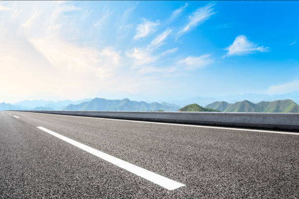 istock Asphalt road and mountains with white clouds 1065274500