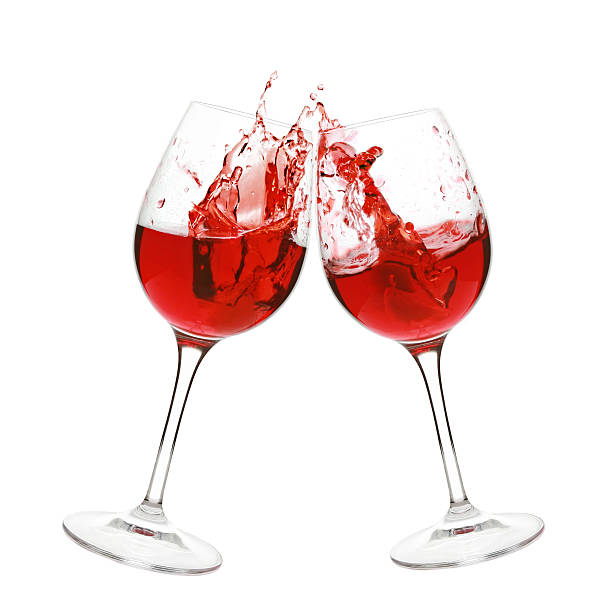 Two glasses of red wine clinking and splashing