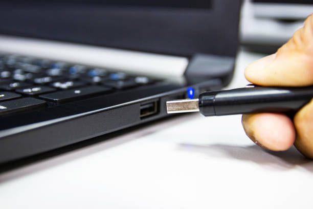 istock USB flash drive on hand man connect to USB port plug-in computer laptop 1065276274