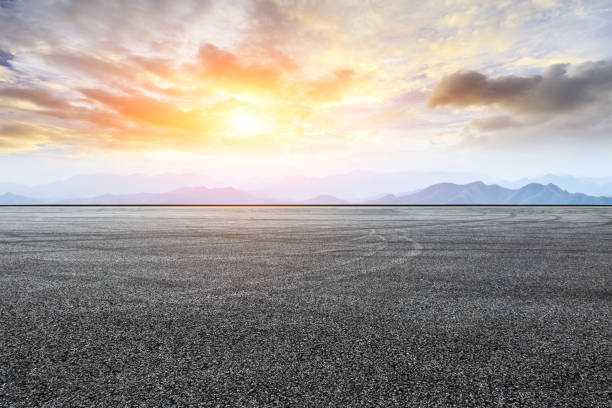 istock Asphalt road pavement and mountain at beautiful sunset 1065276508
