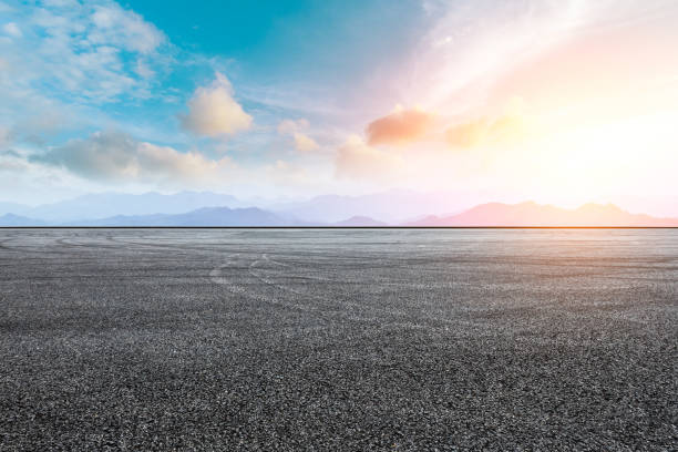 istock Asphalt road pavement and mountain at beautiful sunset 1065276616
