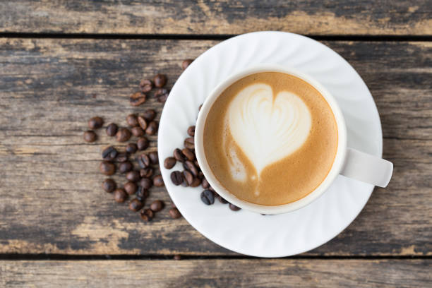 istock coffee cup latte art on old wooden background. top view 1065276632