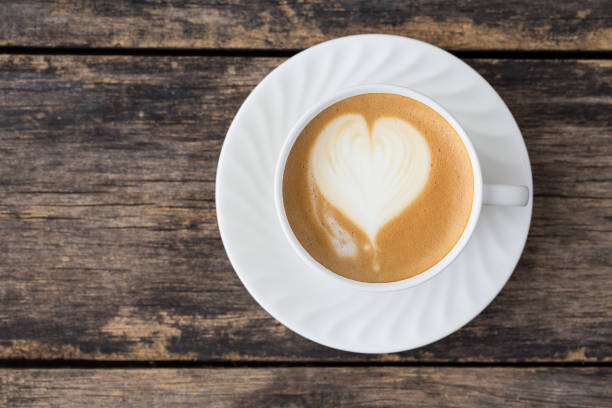 coffee cup latte art on old wooden background. top view