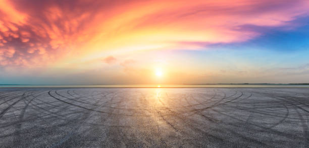 Asphalt road pavement and dramatic sky with coastline