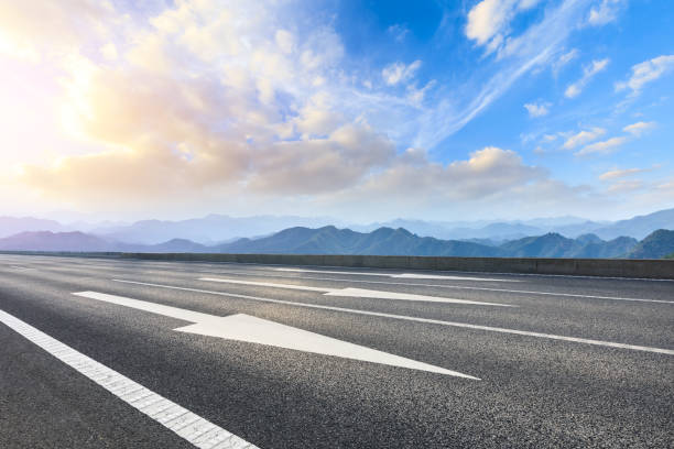 istock Asphalt road and mountains at beautiful sunset 1065280626