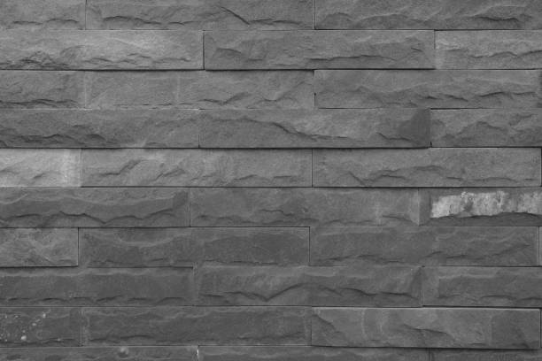 istock Seamless Black pattern of decorative brick sandstone wall surface with concrete of modern style design decorative uneven have cracked realmasonry wall of multicolored stones or blocks with cement. 1065280936