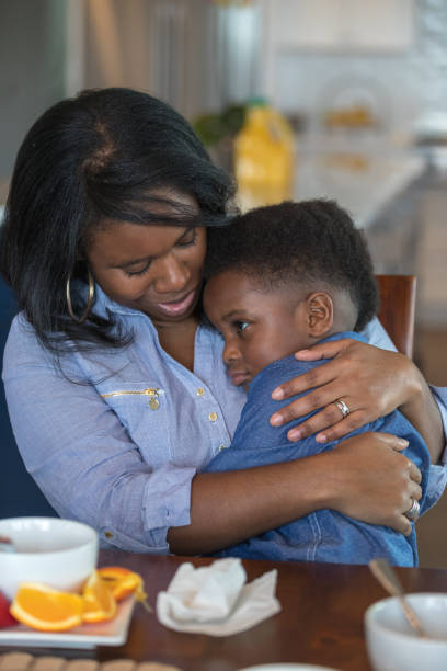 istock Boy sitting in his mom's lap eating breakfast 1065282792