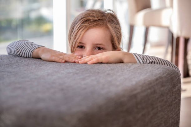 istock young girl peeking over ottoman 1065288552