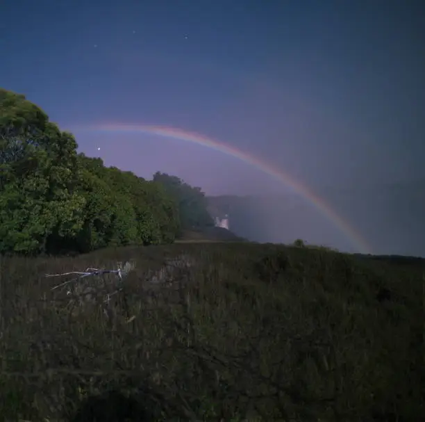 A lunar rainbow or a moonbow on the Victoria Falls observed within 2 days of full moon. Since the lunar rainbows are much fainter than the day-time ones, long-time exposure is mandatory.