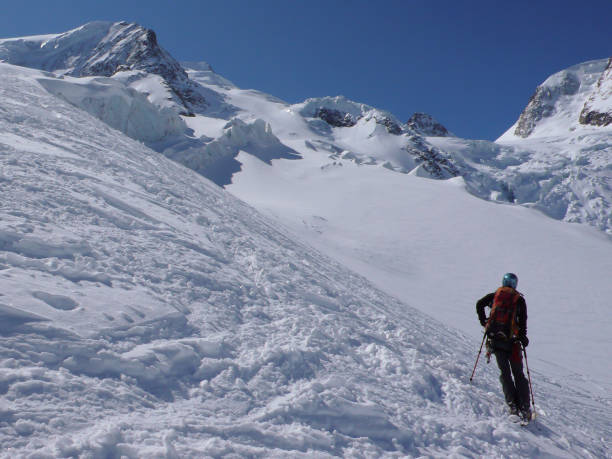 skieur dans l’arrière-pays, profitant de la vue dans les hautes alpes de suisse avec paysage de montagne derrière - piz palü photos et images de collection