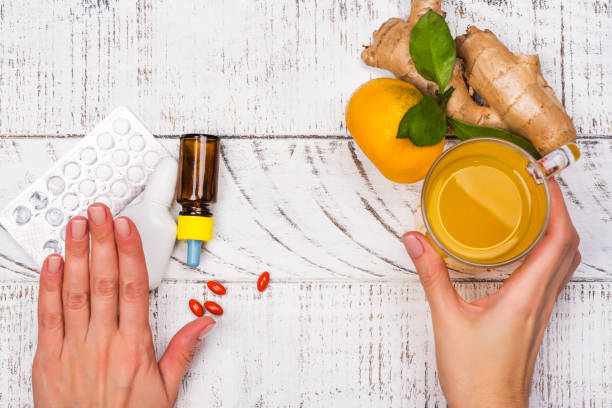 Womans hands holding turmeric drink Woman is choosing natural healthy turmeric drink instead of traditional drugs and pills against flu. Alternative medicine concept. Top view, copy space honey jar liquid gourmet stock pictures, royalty-free photos & images