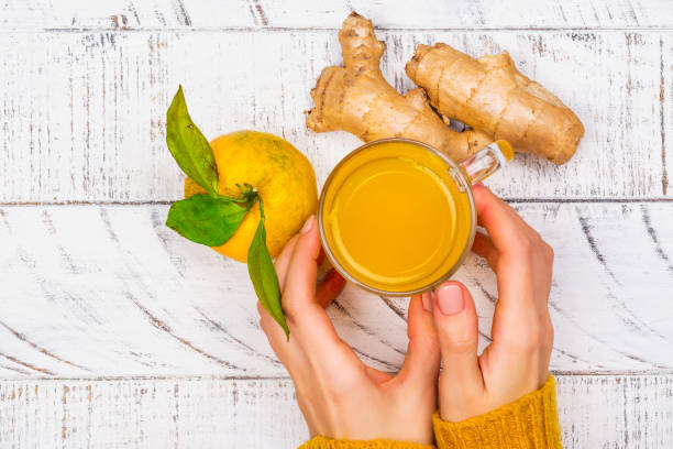 Womans hands holding turmeric drink Woman is choosing natural healthy turmeric drink instead of traditional drugs and pills against flu. Alternative medicine concept. Top view, copy space honey jar liquid gourmet stock pictures, royalty-free photos & images