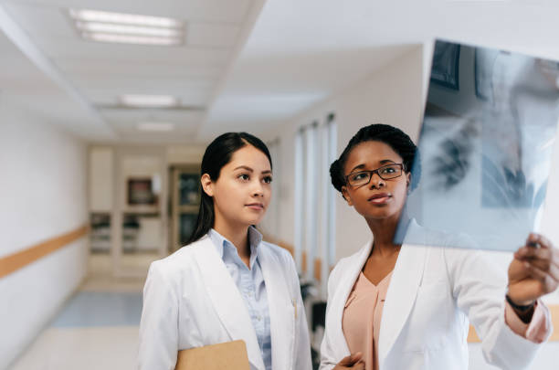istock Two female doctors looking at x-ray in hospital hall 1065300018