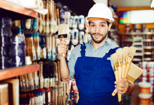 istock foreman in blue overalls choosing brushes 1065302226