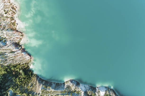 старый гипсовой карьер, наполненный голубой и чистой водой. вид с воздуха сверху вниз - coastline aerial view forest pond стоковые фото и изображения