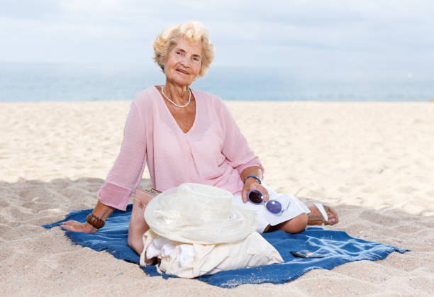 istock Elderly woman relaxing on beach 1065309884