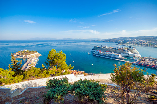 Aydin, Turkey. Three Huge travel cruise ship on tha Kusadasi Harbour. There are hundreds of tourists inside. Also showing an island on the left that named \
