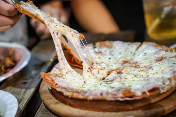 la mano della donna porta le foto della pizza dal piatto della pizza nell'evento foodtruck, la pizza di cheese è cosparsa da lei. - pizza cheese portion mozzarella foto e immagini stock