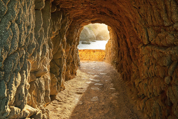 istock Path through a cave to sunrise over the sea 1065318056
