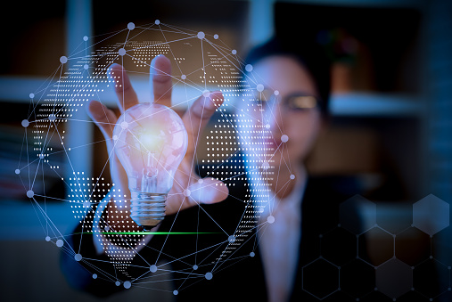Businesswoman holding light bulb on her hands,Technologies connecting the world.