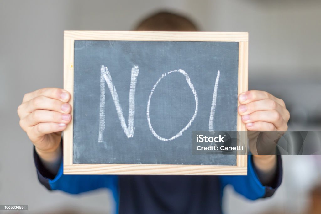 No boy holds blackboard with NO letters Rejection Stock Photo