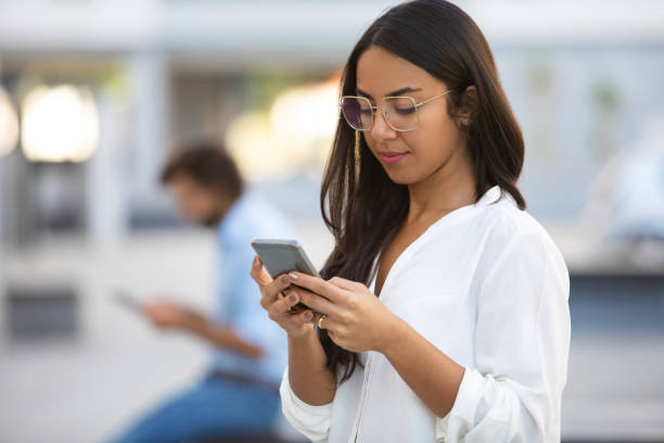 istock Attractive serious woman using smartphone on street 1065334724