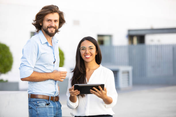 istock Lucky multiethnic partners holding gadget and coffee cup 1065334730