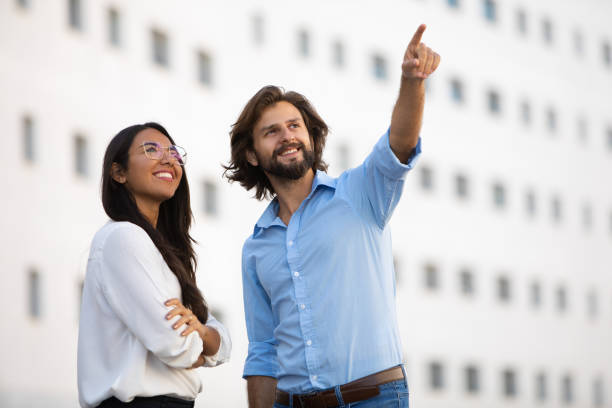 istock Smiling male architect showing building to female partner 1065334828