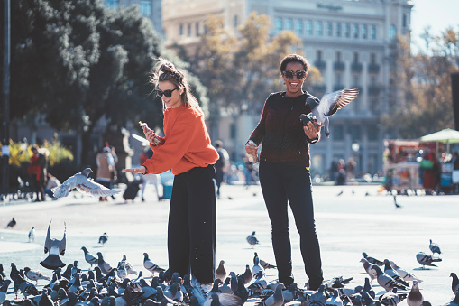 Women in Barcelona feeding pigeons