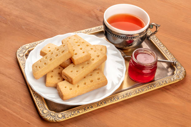 une photo de sablés écossais, typiquement britannique beurre cookies, sur un fond rustique avec une vintage tasse de thé, confiture et un endroit pour texte - five oclock tea photos et images de collection