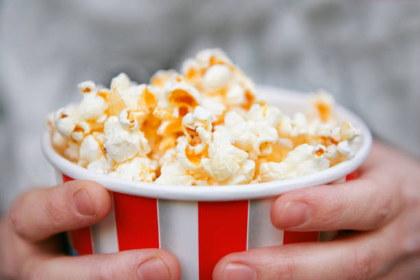 istock close-up of popcorn and hands 1065341754