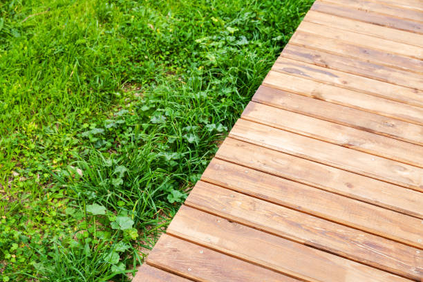 istock New wooden boardwalk over lawn in park 1065343200