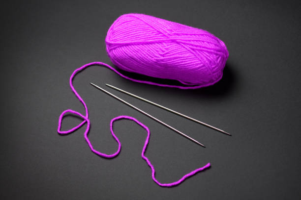 pink ball of woolen thread for knitting on black background