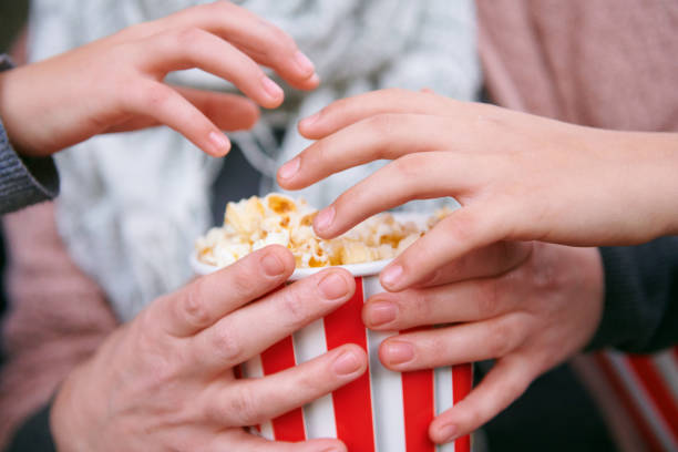 istock close-up of popcorn and hands 1065346260