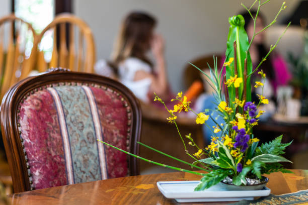 amarillo orquídeas y violetas pequeñas flores en el jarrón de cerámica en la mesa de madera. enfoque selectivo con fondo borroso. - fressness fotografías e imágenes de stock