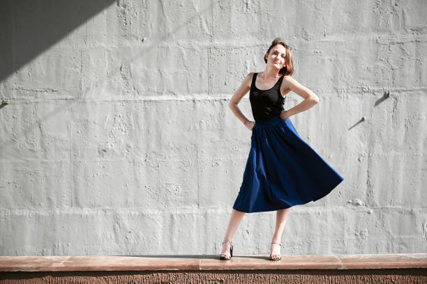 istock young girl posing against a concrete wall, dressed in black, hard light and shadows 1065348552