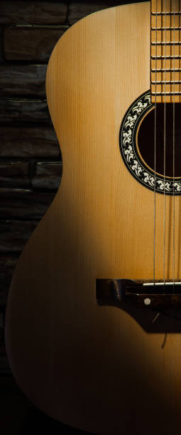 istock Acoustic guitar illuminated by a ray of light against a brick wall. 1065348804