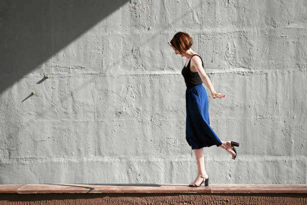 istock young girl posing against a concrete wall, dressed in black, hard light and shadows 1065352200