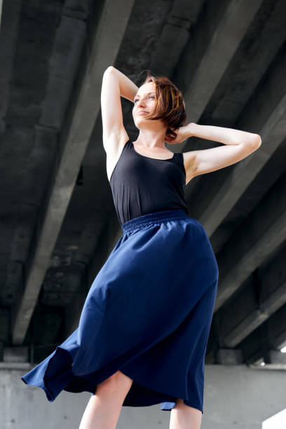 istock young girl posing under the bridge, dressed in black, modern architecture 1065352242