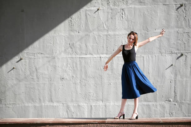 istock young girl posing against a concrete wall, dressed in black, hard light and shadows 1065352372