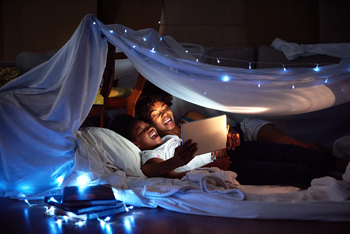 Cropped shot of an attractive young woman using a tablet to read her daughter a bedtime story