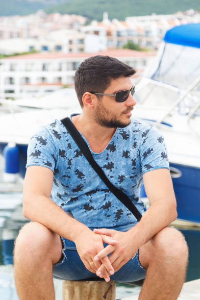 istock A man is seated on a berth on the background of yachts. 1065358252