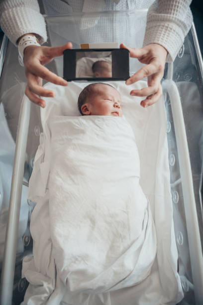 istock Mother photographing newborn son 1065360256