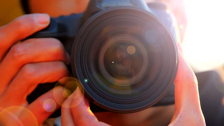 Close-up of young man photographing with camera at sunset