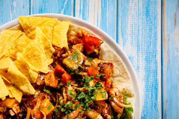 istock Grilled chicken meat, nachos and vegetables on wooden background 1065370310
