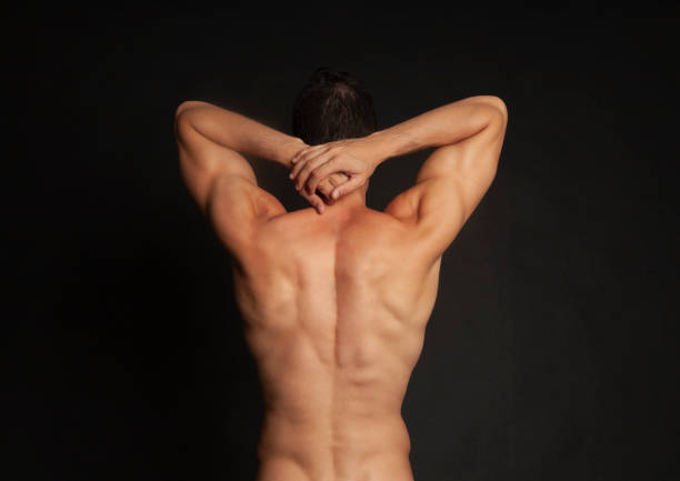 rear view of young man flexing his muscles - rear view human arm naked men imagens e fotografias de stock